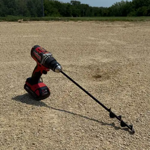SMART Base Auger on a standard drill, cleaning a base anchor on an infield